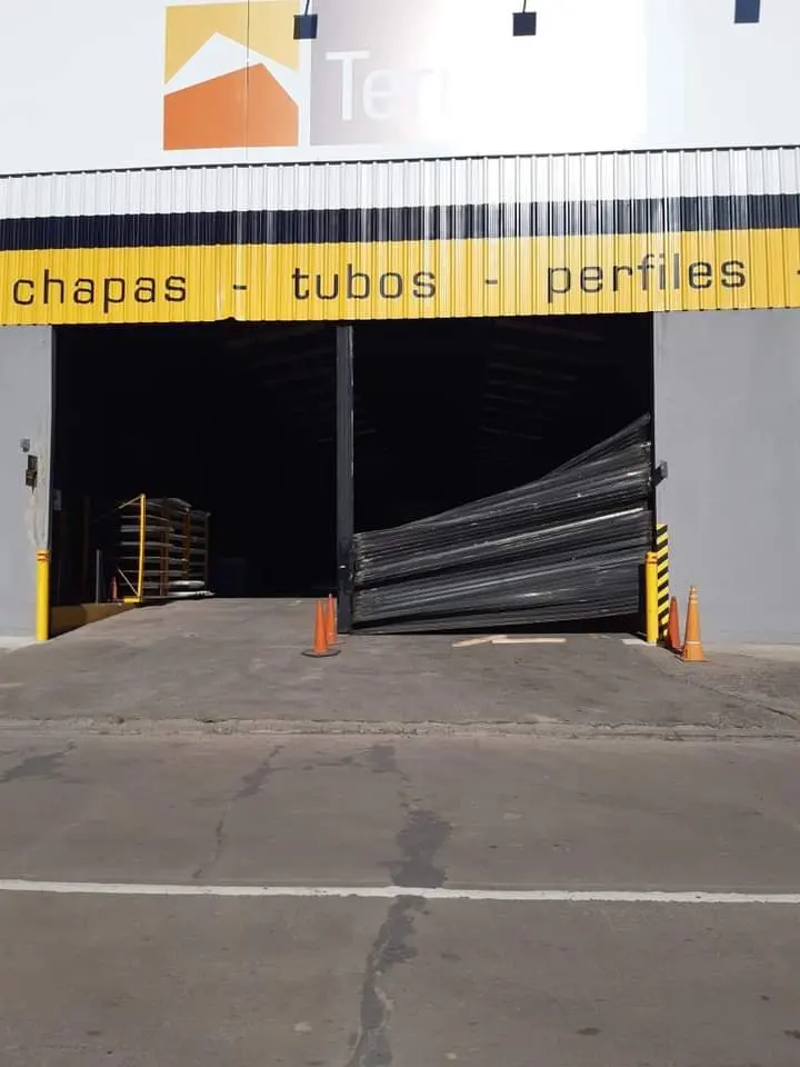 Cortina metálica dañada en depósito industrial,  de reparar
